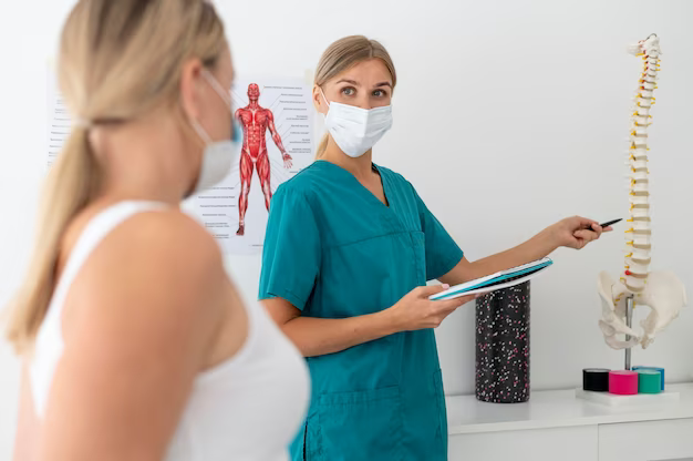 Doctor showing model of spine to patient