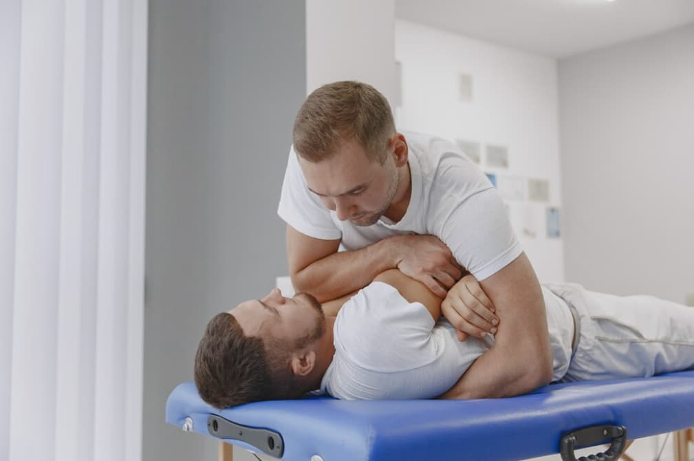 A chiropractor is conducting a neck adjustment on a man