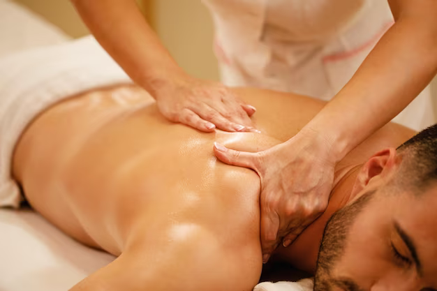 Massage therapist giving a back massage to a man